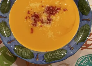 Crema de calabaza con perlas de pera y polvo ibérico